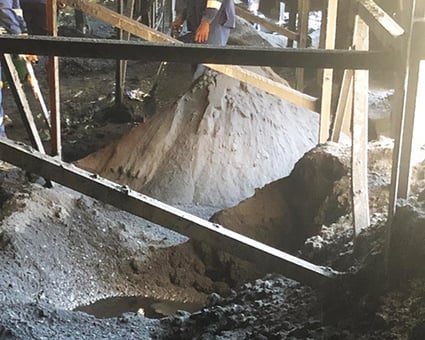 Material piling underneath the conveyor and spilling onto walkways is dangerous and nonproductive